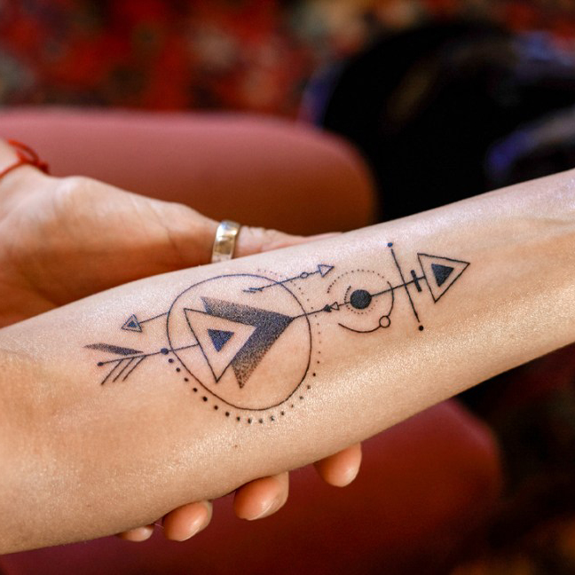 woman-demonstrating-just-finished-creative-arrow-tattoo-on-her-hand-1296×728-header